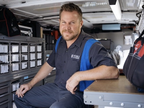 A Noble Locksmith technician sitting inside his fully-outfitted van.